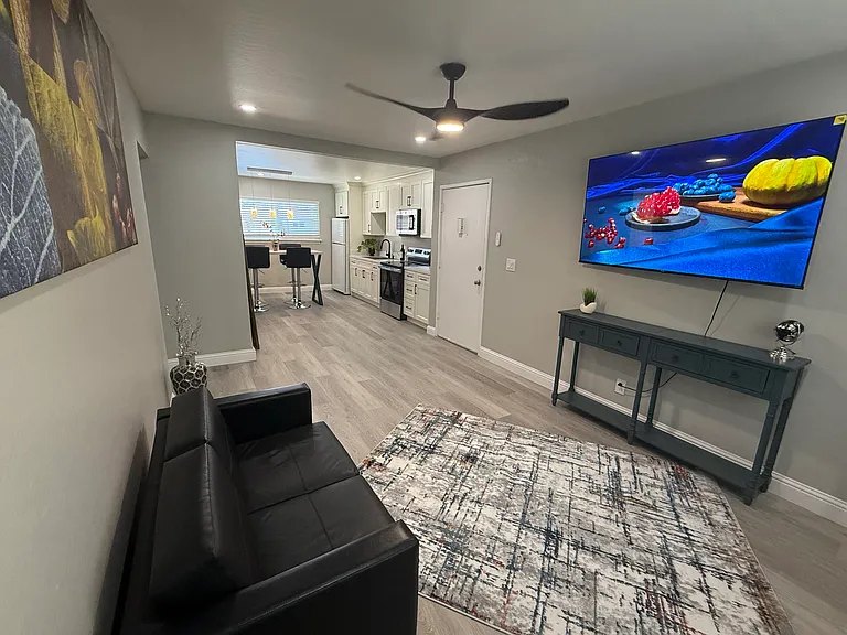 Living room with ceiling fan and mounted TV