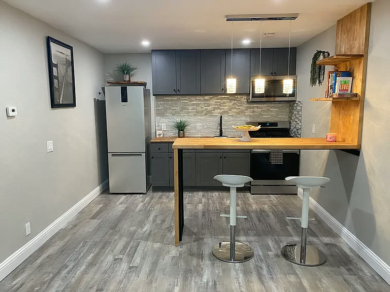 Kitchen and breakfast bar with pendant lighting and stainless appliances