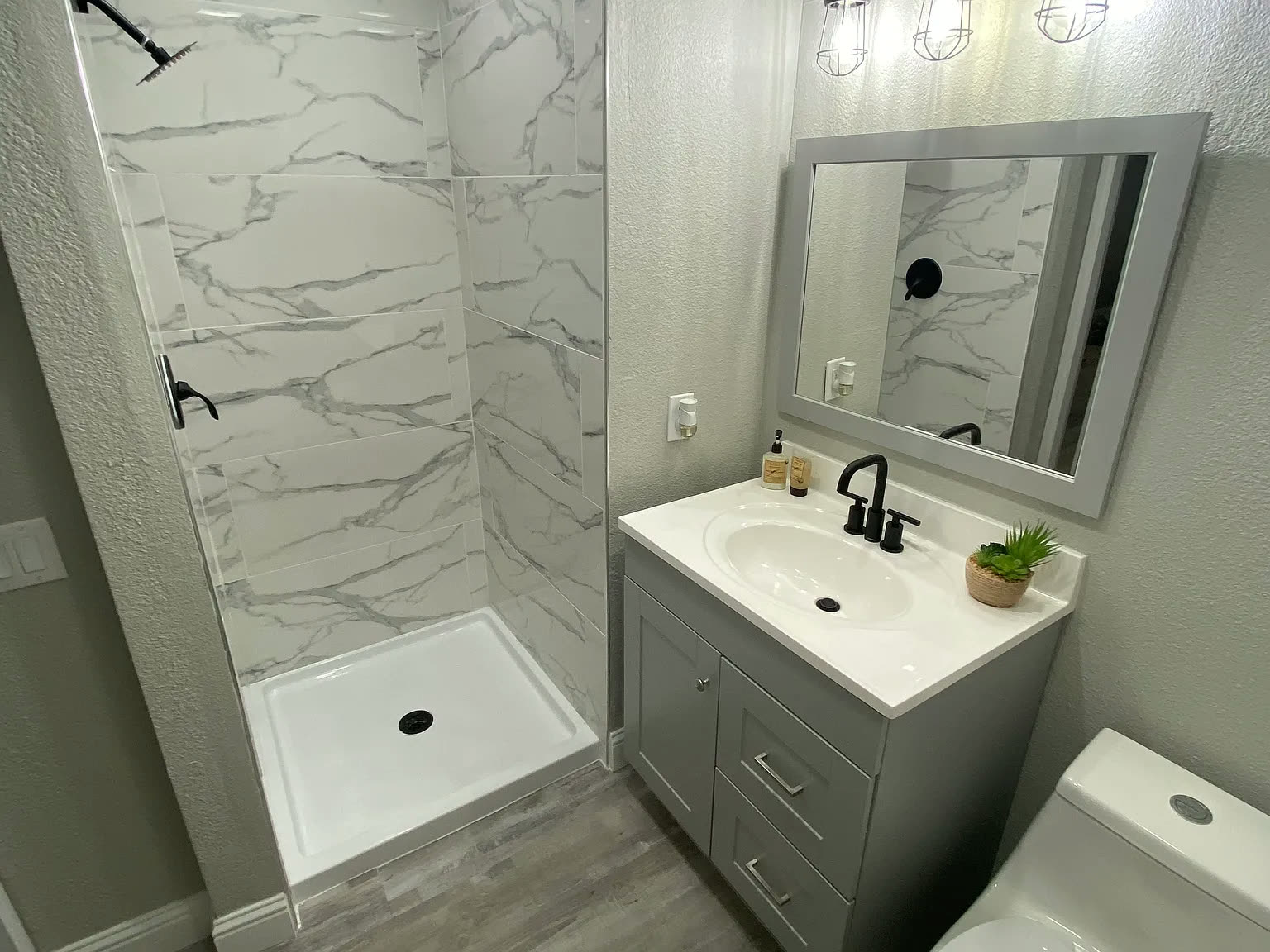 Updated bathroom with marble-look tile shower and modern vanity