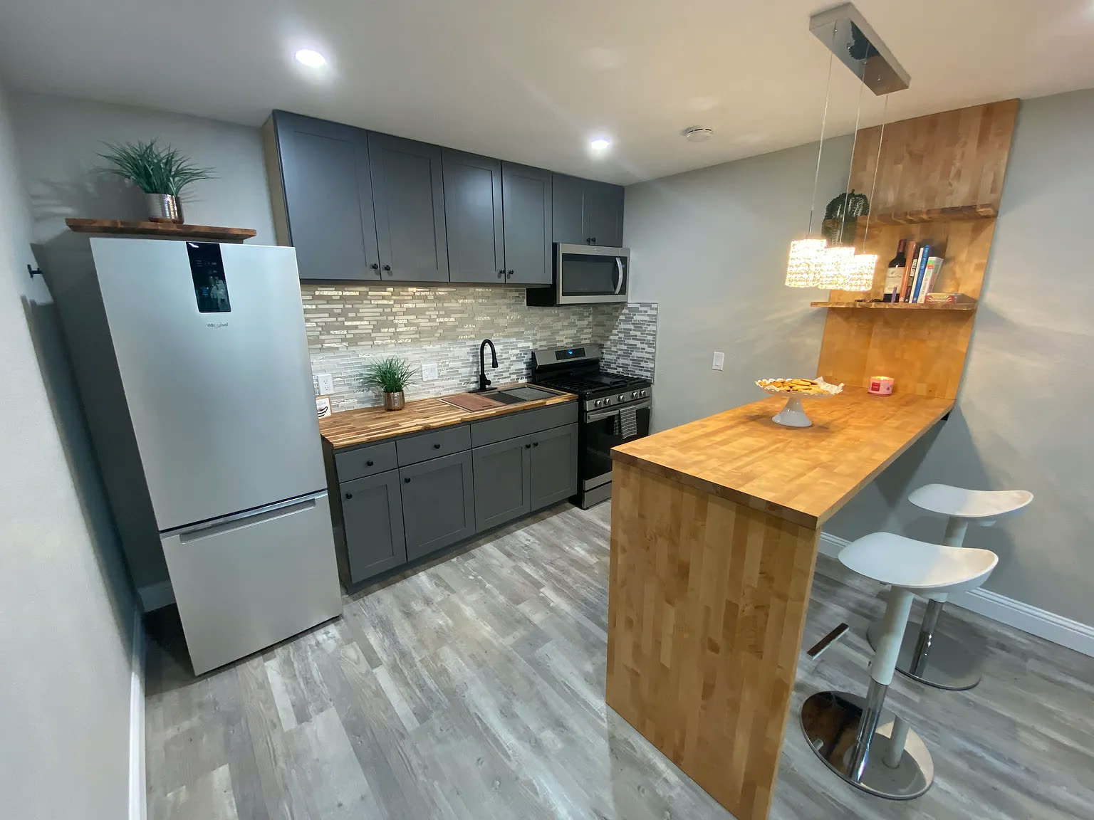 Renovated kitchen with gray shaker cabinets and butcher-block counters