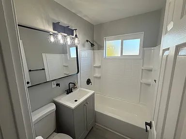 Updated bathroom with tub, tile surround, and modern vanity